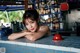 A woman leaning on a counter in front of a bar.