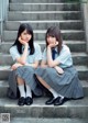 Two young women sitting on the steps of a building.