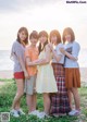 A group of young women standing next to each other on a beach.