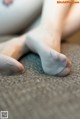 A close up of a woman's feet on a couch.