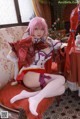 A woman in a red and white outfit sitting on a chair.