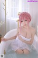 A woman with pink hair sitting in a bathtub.