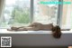 A naked woman laying on a window sill.