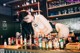 A woman in lingerie leaning over a bar counter.