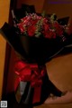 A person holding a bouquet of red roses in their hand.