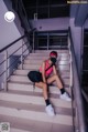 A woman wearing a face mask sitting on a set of stairs.