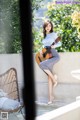 A woman sitting on a bench holding a guitar.