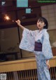 A woman in a blue kimono holding a sparkler.