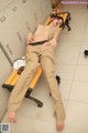 A woman laying on a bench in a locker room.