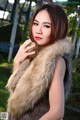 A woman in a fur vest posing for a picture.