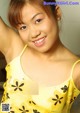 A woman in a yellow dress posing for a picture.