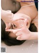 A woman laying on a bed making a peace sign with her hands.