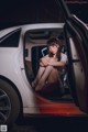 A woman sitting in the back of a white car.