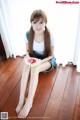 A woman sitting on the floor holding a slice of watermelon.