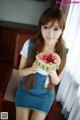 A young woman holding a slice of watermelon in her hand.