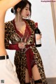 A woman in a leopard print robe holding a glass of wine.