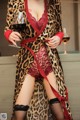 A woman in a leopard print robe holding a glass of wine.