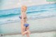 A woman in a bikini standing on the beach.