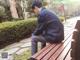 A man sitting on a wooden bench in a park.