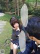 A man and a woman sitting on the grass in a park.