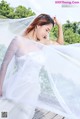 A woman in a wedding dress with a veil over her head.