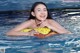 A woman in a yellow bikini floating in a pool.