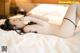 A woman laying on top of a bed in a black lingerie.