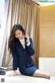 A woman in a business suit talking on a cell phone.