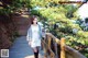 A woman standing on a wooden bridge in a forest.