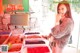 A woman standing in front of a display of dried fruits.