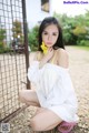 A woman in a white dress sitting on the ground.