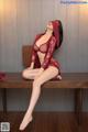 A woman in a red lingerie sitting on a wooden bench.