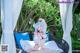 A woman in a bikini sitting on a wicker chair.