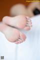 A close up of a person's feet on a bed.