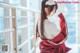 A woman in a red and white outfit is posing for a picture.