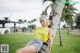 A woman leaning against a palm tree in a park.