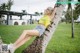 A woman leaning against a tree in a park.