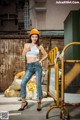 A woman wearing a hard hat standing in front of a building.