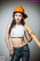 A woman in a hard hat holding a baseball bat.