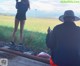 A man taking a picture of a woman standing on a train track.