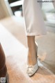 A close up of a woman's shoes on a carpeted floor.