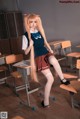 A woman in a school uniform sitting at a desk.