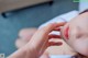 A woman laying on a bed with her hand on her face.