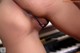 A close up of a woman's butt with a piano in the background.