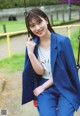 A woman in a blue suit sitting on a swing.