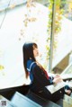 A woman sitting on a bench reading a book.