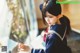 A little girl in a sailor outfit looking out a window.