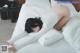 A woman laying on top of a bed with white sheets.