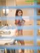 A woman standing in front of a mirror in a bathroom.