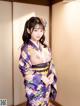 A woman in a purple kimono posing for the camera.